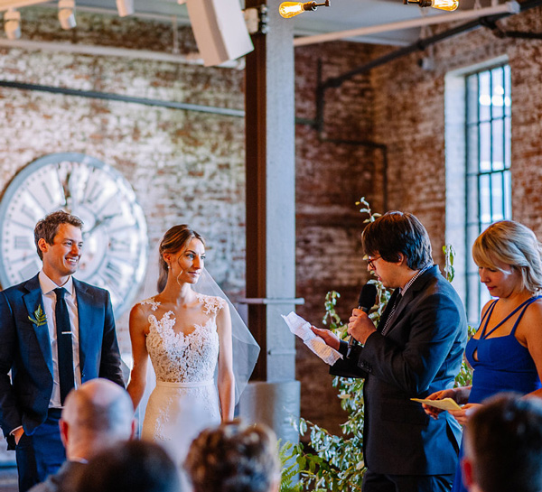 bride and groom listening to reading during ceremony